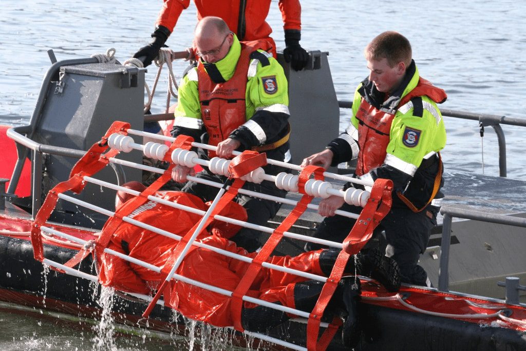 Boat crew recovering man from the water by using a Dacon Rescue Frame