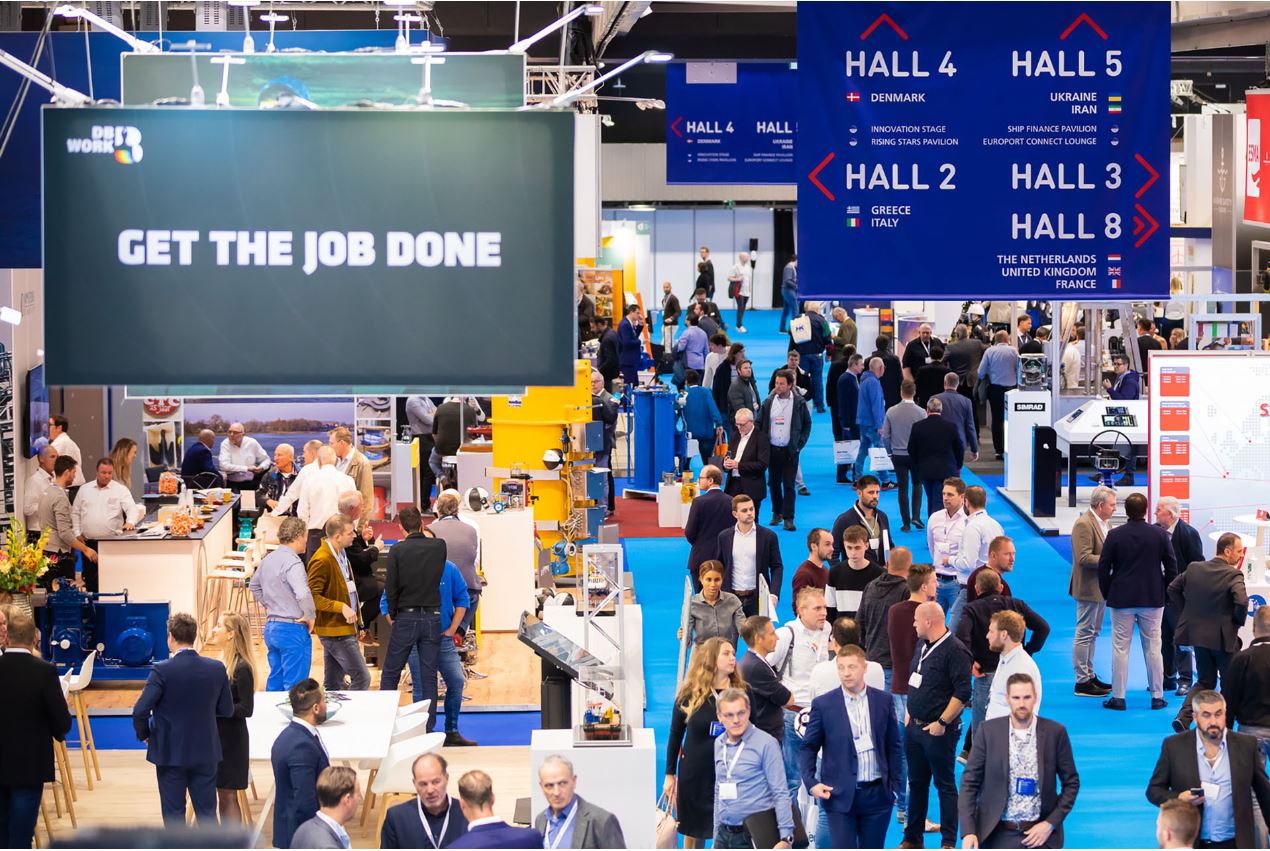 Peopl walking around at an excibition.