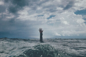 A hand waving in the ocean. Person drowning.